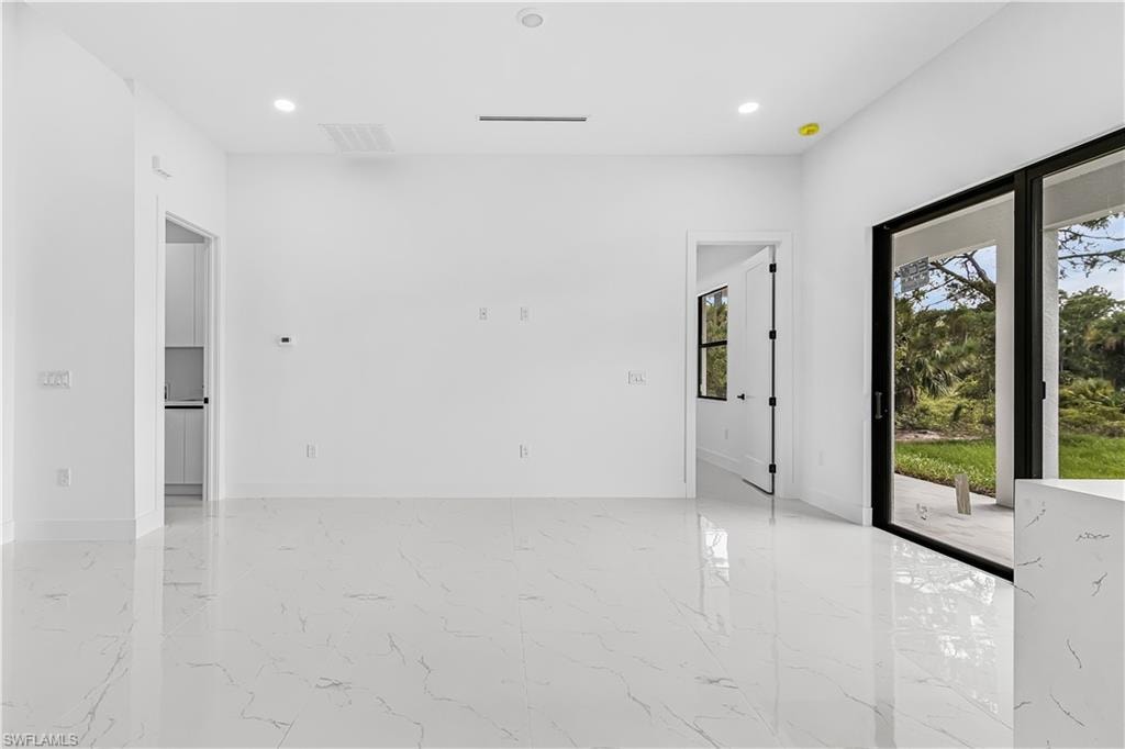 Spacious room with white walls and large-format tile flooring