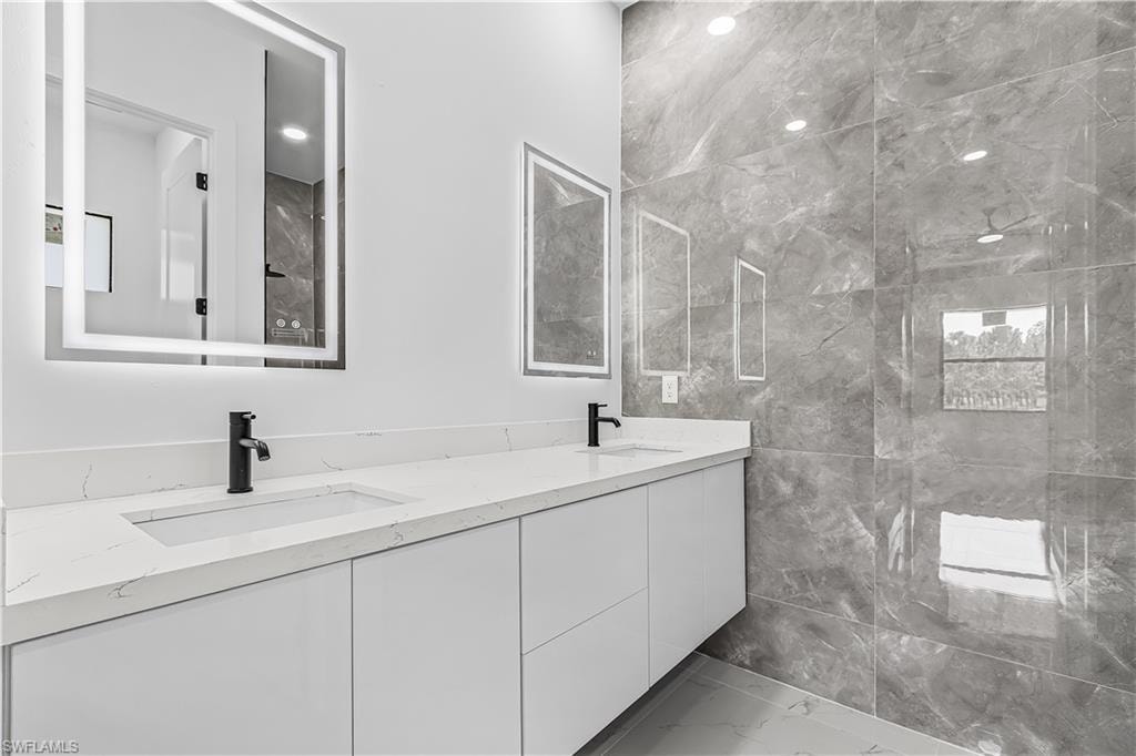 Dual vanity with white cabinetry, integrated sinks, white countertops, and matte black fixtures