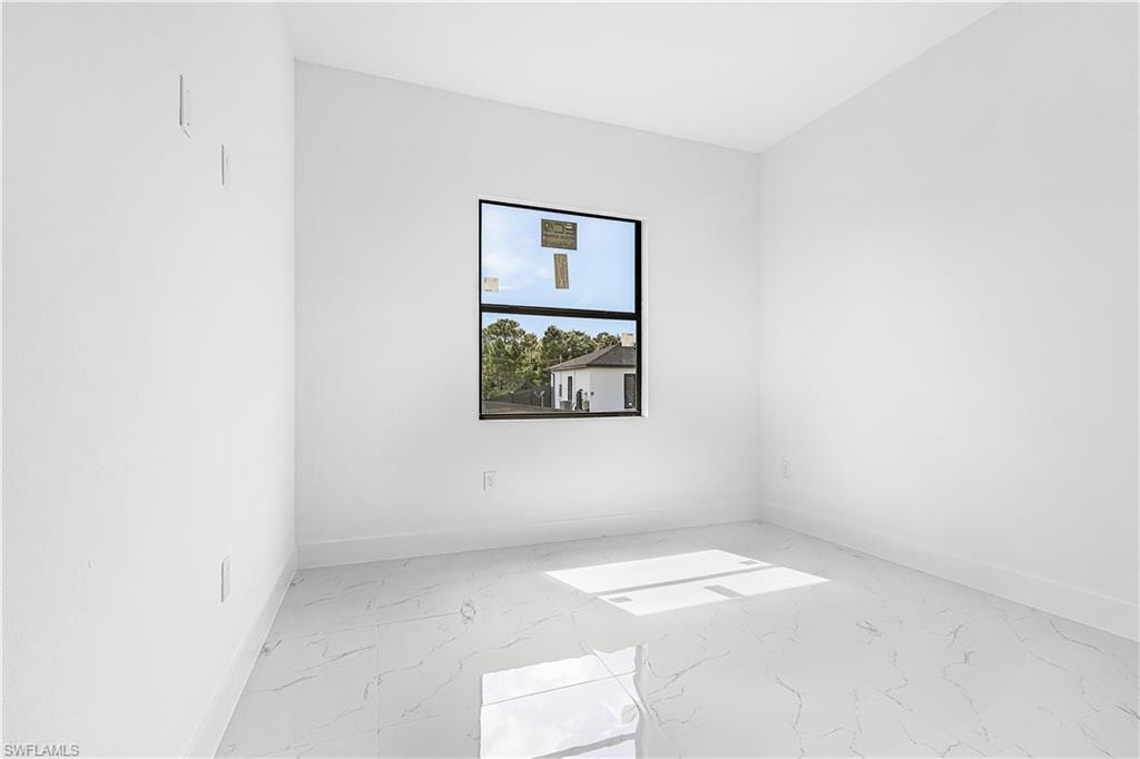 White walls and ceiling, single window with dark framing, and light-colored tile flooring