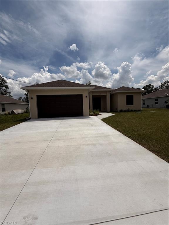 Contemporary stucco exterior, large concrete driveway, two-car garage, established front lawn, and a concrete walkway