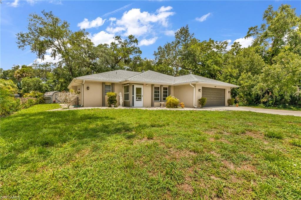 Front and side view of 297 Flamingo Boulevard Port Charlotte 33954, 1729 Sq ft, 3 BR ( one can be used as a den/office space) , 2 Baths, and 2 Car Garage on Waterfront with Landscaped Backyard.