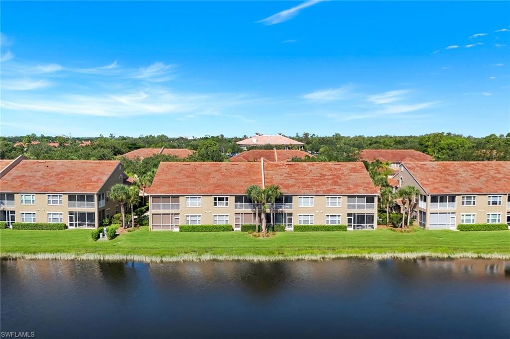 Community buildings featuring tile roofing and multiple screened balconies overlooking a body of water