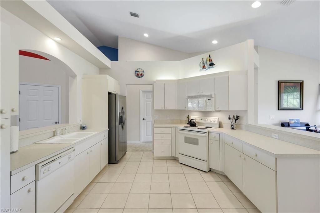 Bright Kitchen with Ample Counter Space, White Cabinetry, Breakfast Bar, and Recessed Lighting