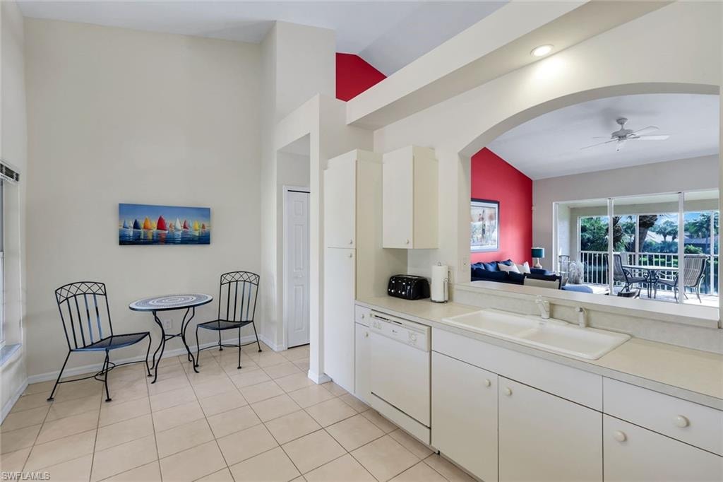 Kitchen featuring white cabinetry, a double basin sink, and a built-in dishwasher