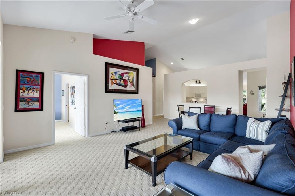 Spacious Great Room Featuring a Vaulted Ceiling, Recessed Lighting, Ceiling Fan, Arched Pass-Through, Primary Bedroom Entry, and Kitchen Access