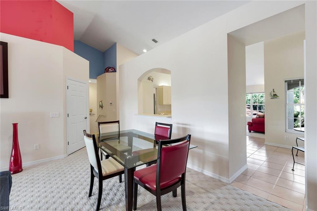 Dining Area Featuring Vaulted Ceilings with Architectural Details, an Arched Kitchen Pass-Through, Recessed Lighting, and Easy Access to the Breakfast Nook