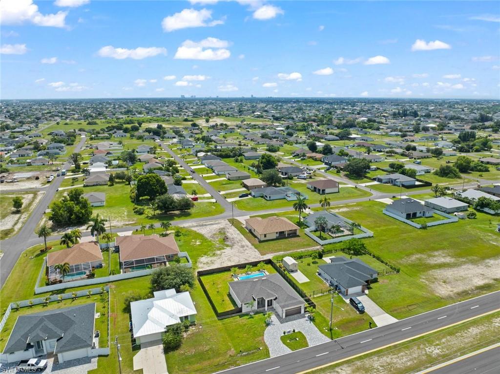 Aerial perspective of a residential community with single-story homes and landscaped yards