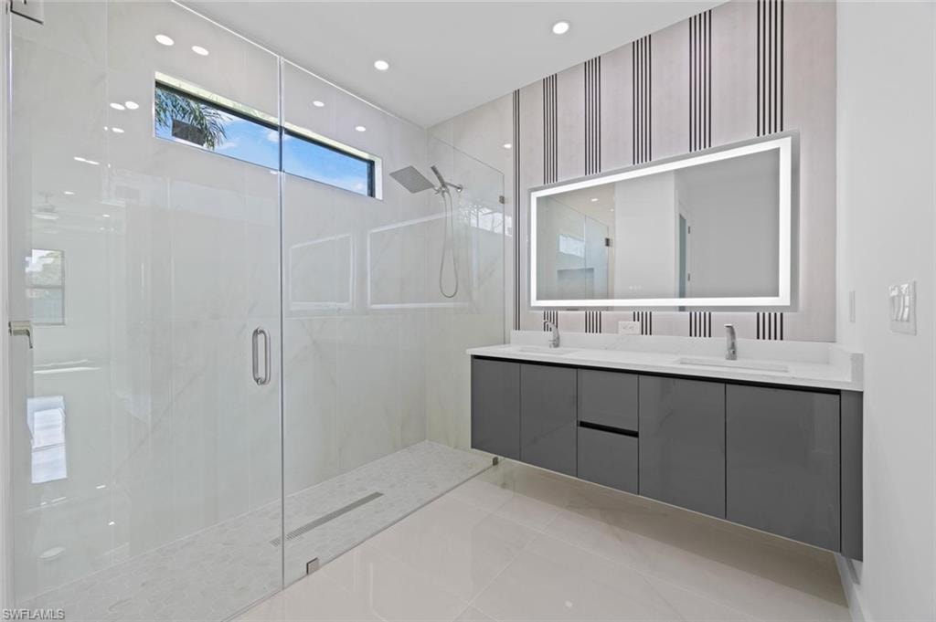 Spacious shower with glass enclosure and rainfall showerhead