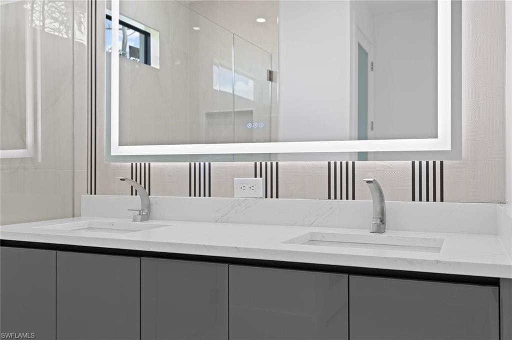 Dual integrated sinks set within a white countertop, complemented by sleek gray cabinetry