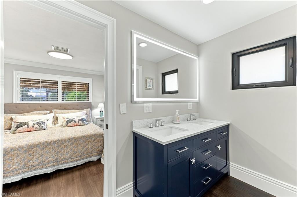 Dual sink vanity with a stone countertop and an illuminated mirror