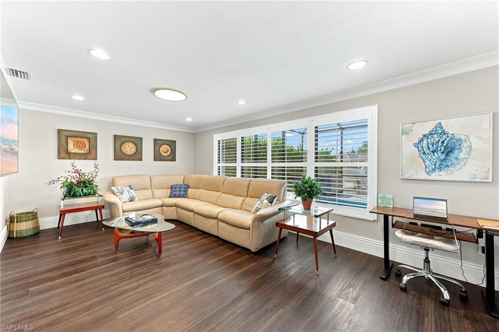 Wood-finish flooring throughout, recessed ceiling lighting, and crown molding