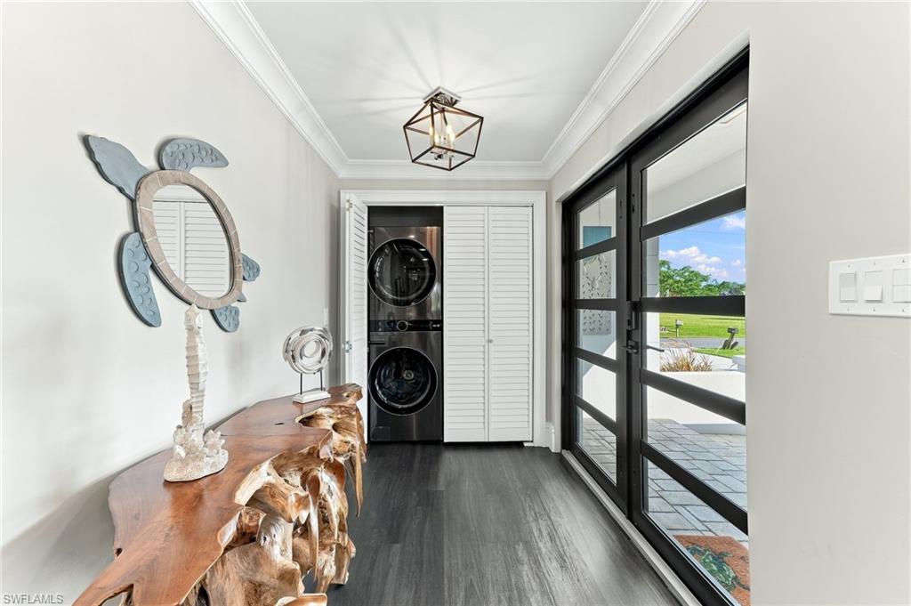 Dark wood-finish flooring, crown molding, and a modern geometric ceiling light fixture