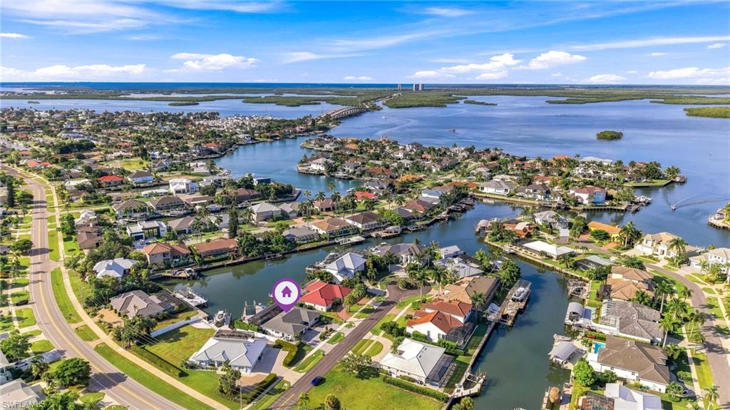 Waterfront property with direct canal access, a private dock, and a red tile roof