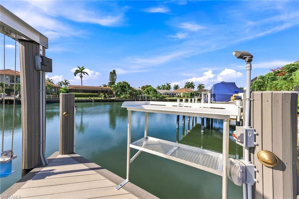 Dock with composite decking, featuring a boat lift, built-in lighting, and a processing station