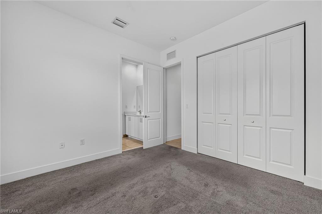 Plush carpet flooring, white painted walls, bi-fold closet doors, and recessed lighting