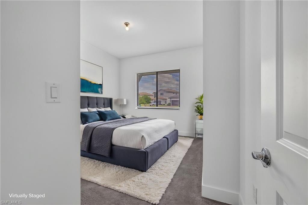 Bedroom featuring a window with horizontal blinds, overhead lighting, and carpet flooring