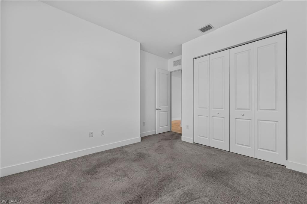 Recessed ceiling light, white panel doors, wall-to-wall carpeting, and white baseboards