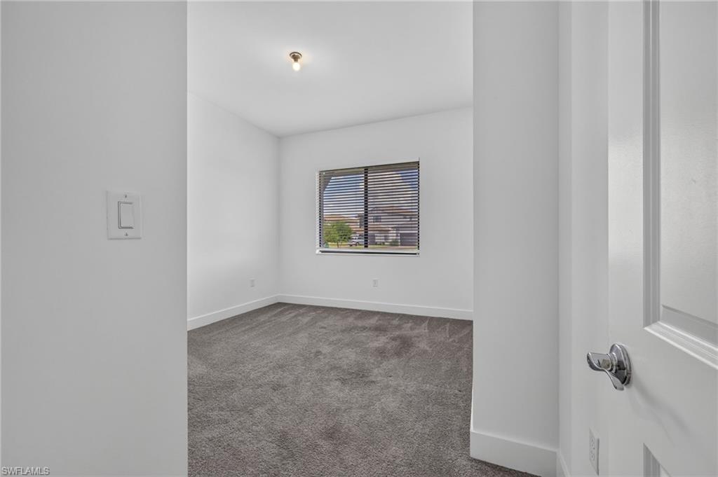 Neutral wall finishes, recessed window, and gray carpet flooring