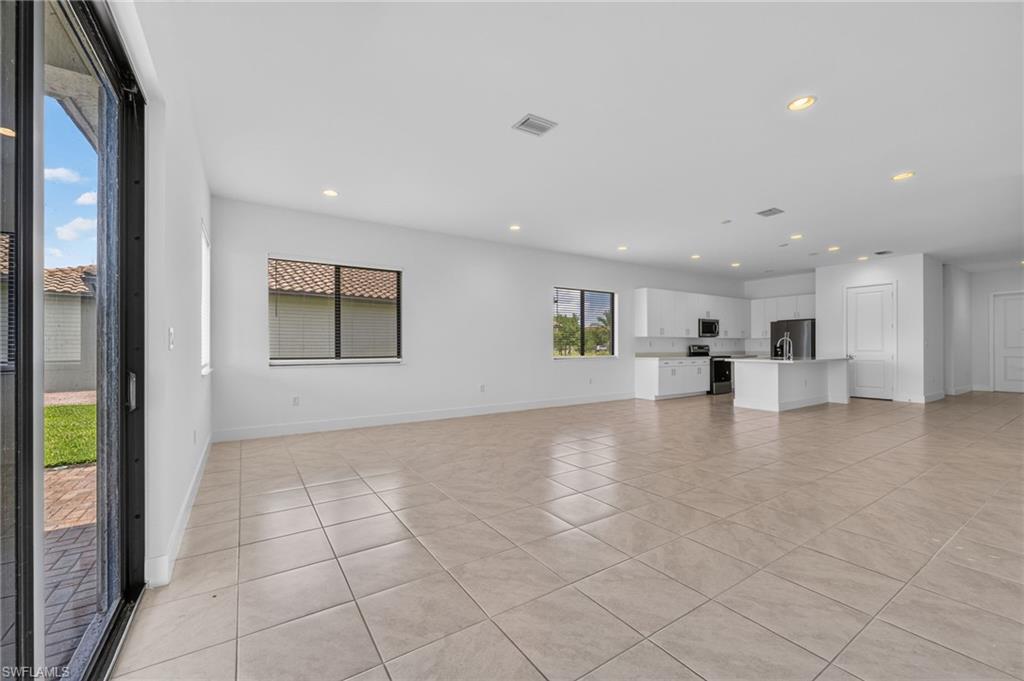 Open-concept living space featuring tiled flooring, recessed lighting, and white walls