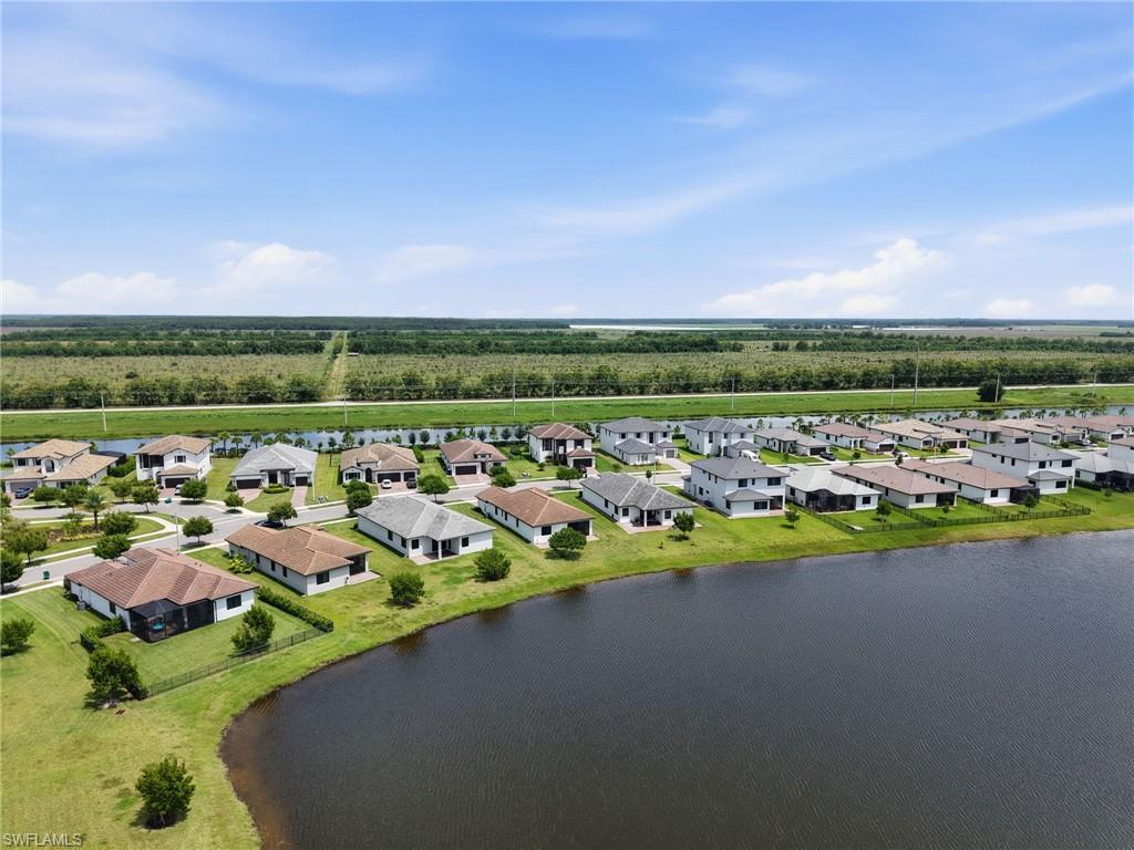 Waterfront properties with lush green landscaping, a variety of architectural styles, and paved streets