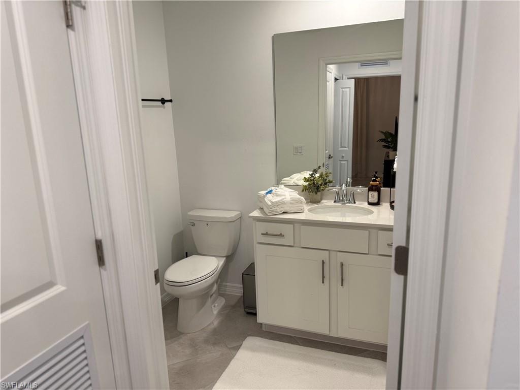 White vanity with a built-in sink, chrome fixtures, and a large wall mirror