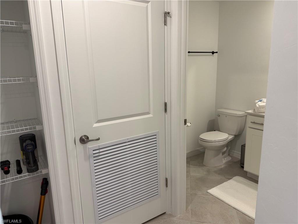 White paneled door with louvered vent, adjacent to a storage closet with wire shelving