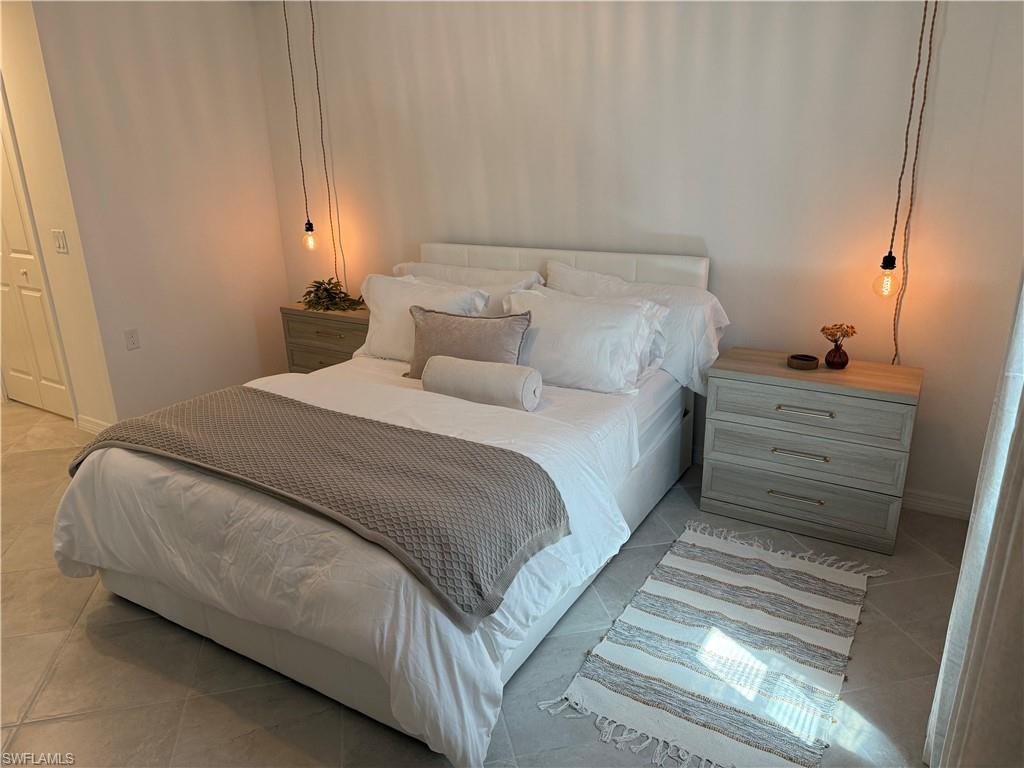 White walls with a textured finish, light-toned tile flooring, and integrated lighting fixtures