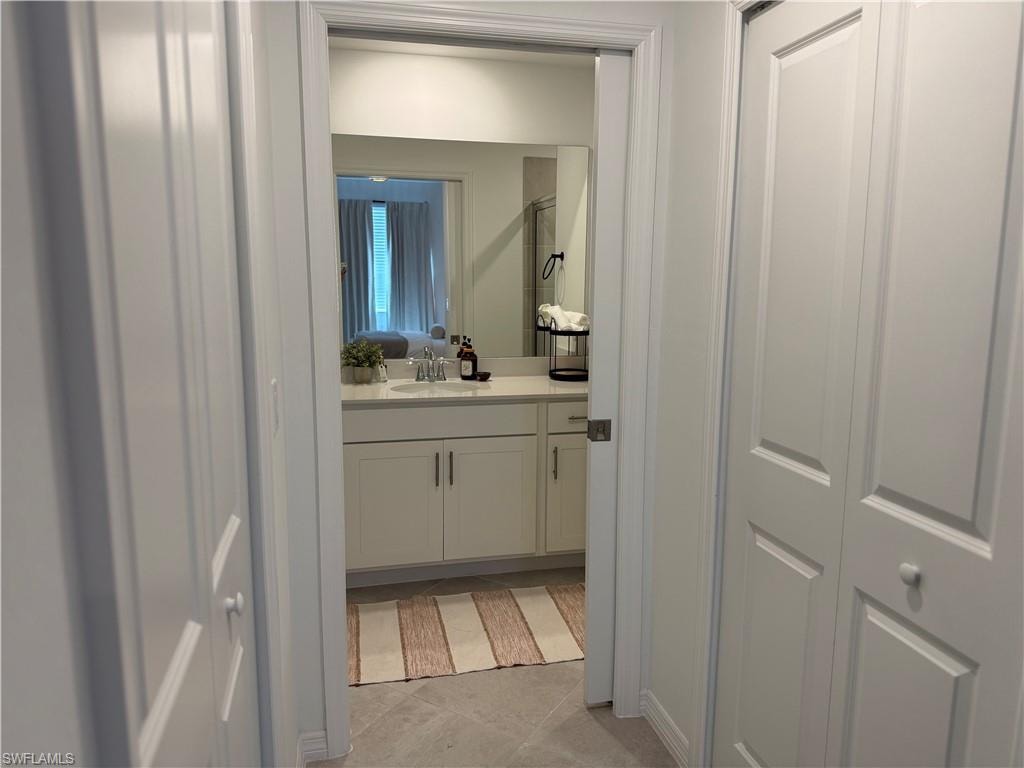 White paneled bi-fold doors, flat-panel interior doors, and tile flooring