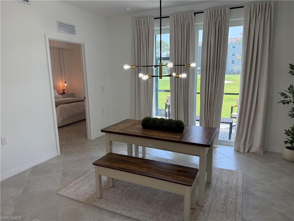 Oversized sliding glass doors, tile flooring, contemporary chandelier, white walls, and recessed lighting