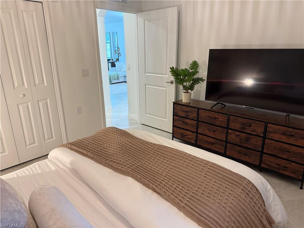 White bi-fold closet doors, white interior door with polished hardware, white wall finishes, and light-toned flooring