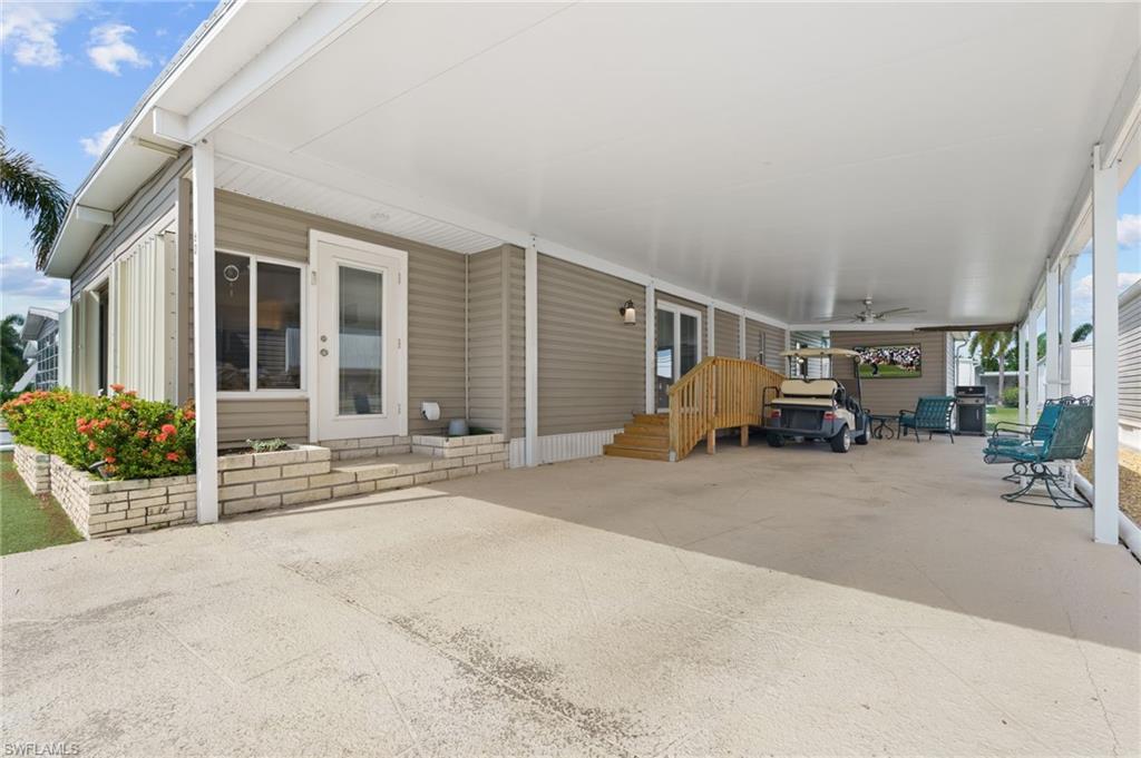 Oversized covered carport provides generous parking and shaded outdoor living space.