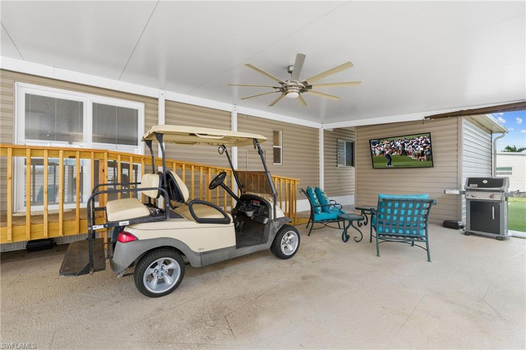 The oversized carport functions as an outdoor living area. Electric golf cart included.