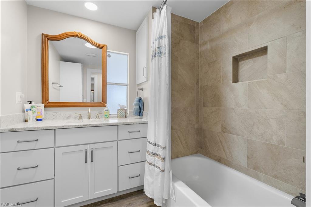Updated guest bathroom with a tiled tub and shower surround.