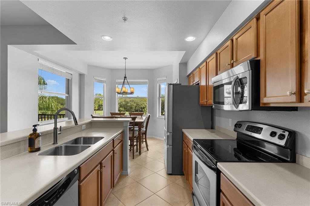Kitchen featuring wood-finish cabinetry, stainless steel appliances, a dual basin sink.