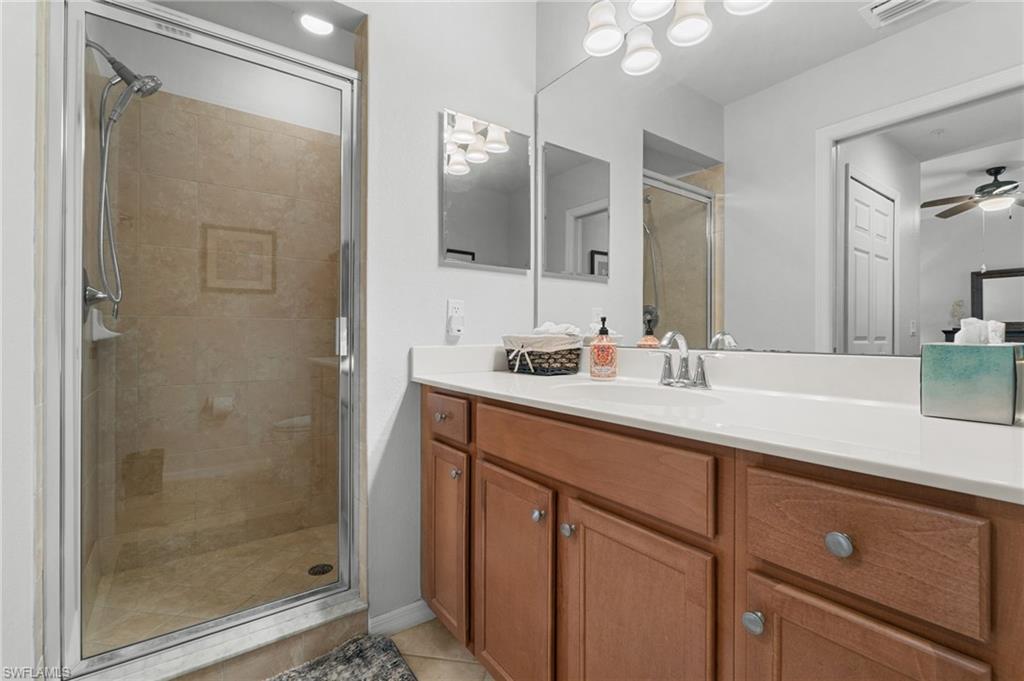 Master bathroom; shower with tiled surround, glass enclosure, and mounted shower head