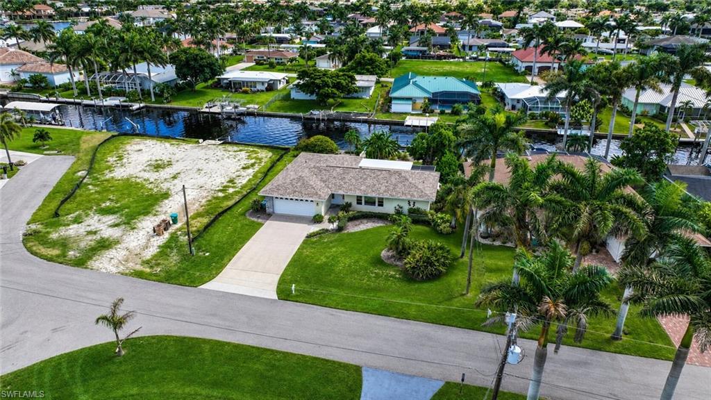 Single-story residence with an attached garage, paved driveway, and mature landscaping