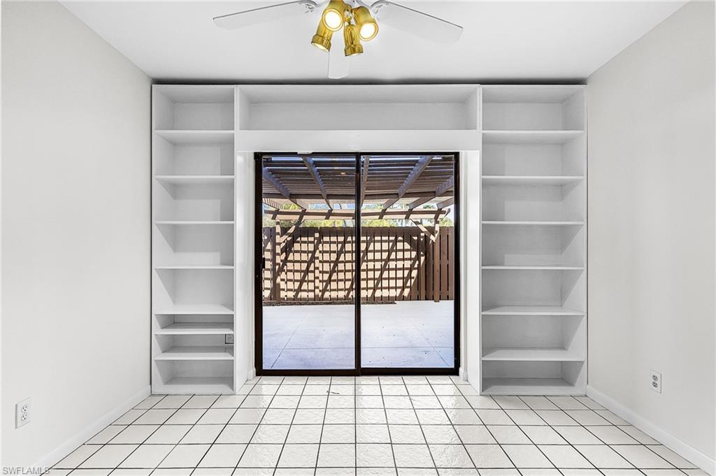 Built in shelving for books, artwork, decorative items flank the sliding doors the enter the private pergola covered patio.