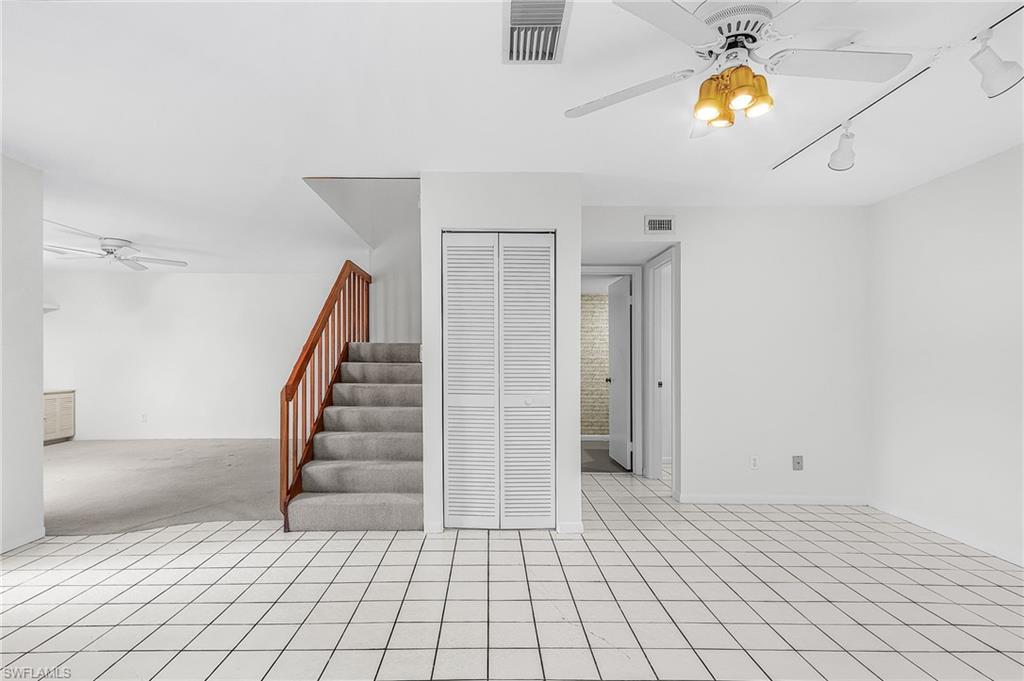 View from the kitchen. Living is left of stair case, louvered doors hide a storage/HWH utility area, laundry room and half bath are on the right.