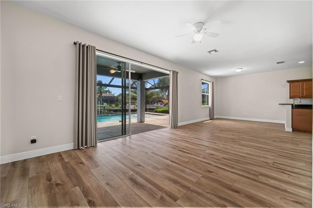 Large great room opens directly to the screened pool and lanai through sliding glass doors. The layout creates an effortless transition from indoor living to the home's canal-side outdoor entertaining areas.