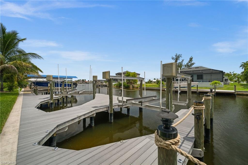 Close view of the custom dock showcases the dual boat-lift configuration and expansive waterfront platform. The documented remote-controlled lifts are rated at 10,000 pounds and 16,000 pounds.