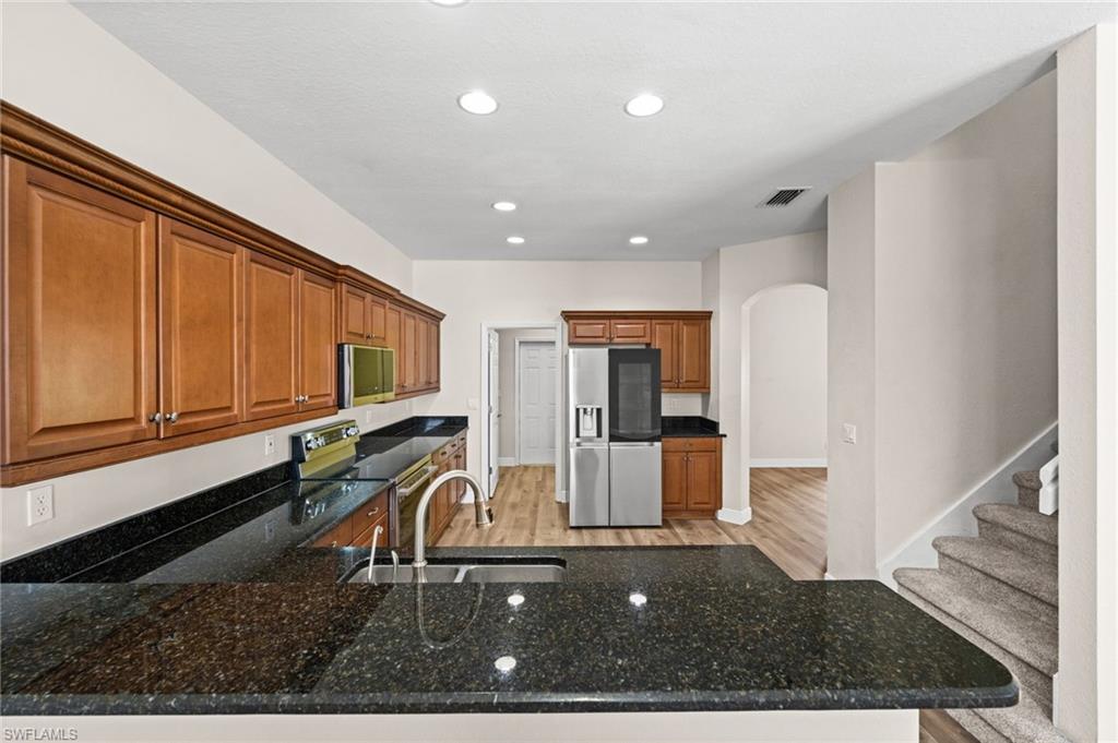 Granite breakfast bar provides additional preparation space and an area for casual seating while opening the kitchen to adjoining living areas. Extensive cabinetry and stainless appliances add everyday functionality.