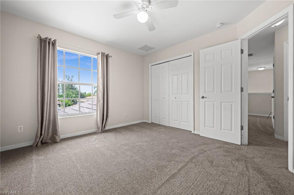 Another view of the third and fourth bedroom highlights its comfortable proportions, ceiling fan, window, and double closet. The straightforward layout offers practical furniture-placement options.