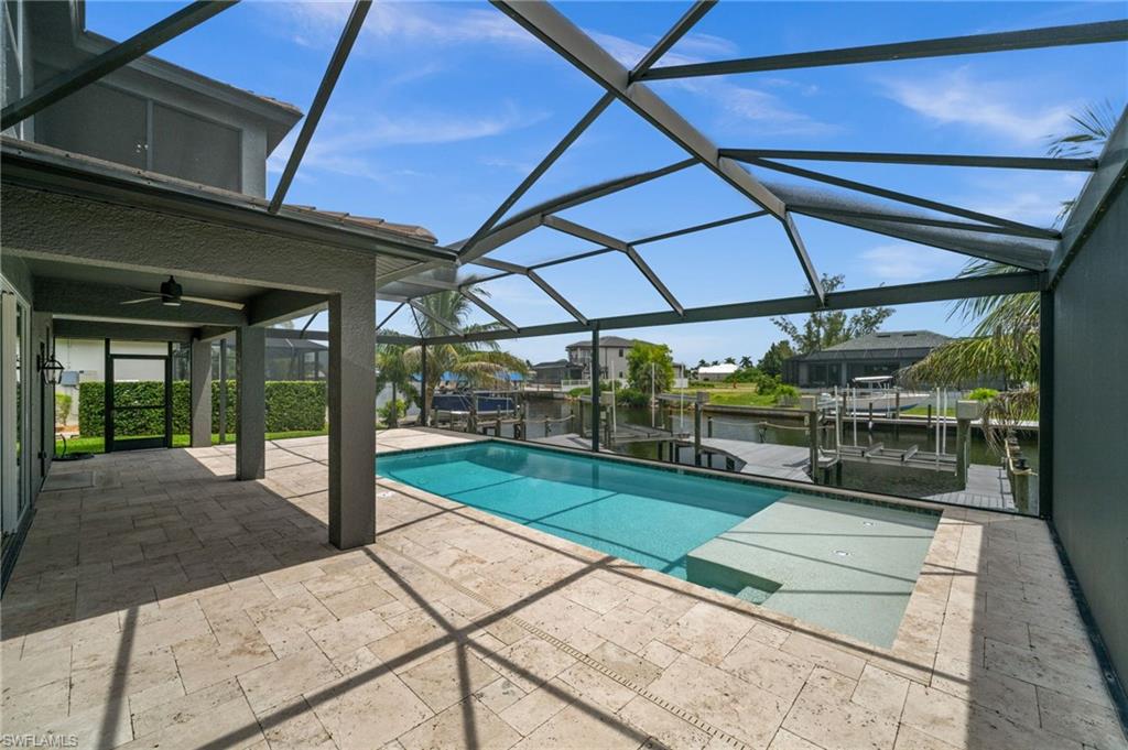 Screened swimming pool overlooks the canal and private dock, creating a relaxing outdoor setting for everyday living and entertaining. The pool, waterfront view, and boating setup combine several of the property's strongest lifestyle features.