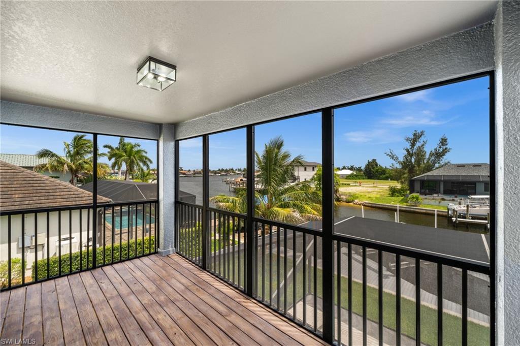 Private screened second-floor balcony provides elevated canal views, palm-lined scenery, and a peaceful place to enjoy the Southwest Florida climate away from the main pool deck.