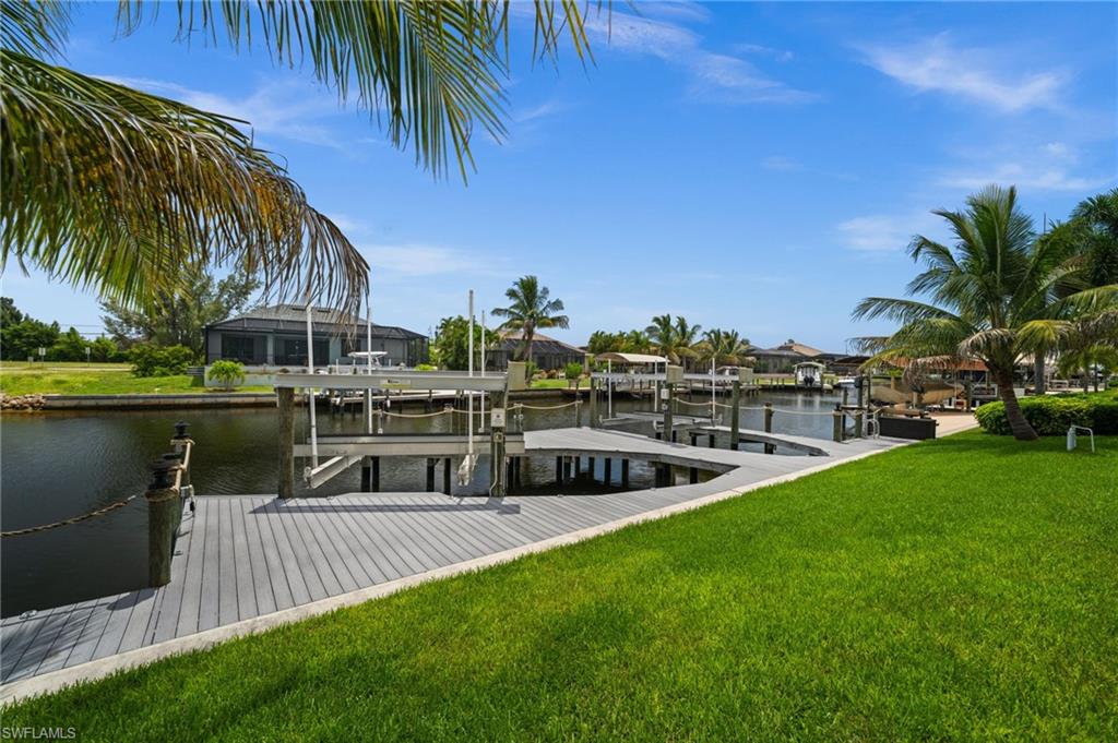 Lush backyard leads directly to the custom waterfront dock and boat lifts. Framed by mature palms and canal views, this outdoor area captures the boating lifestyle associated with Cape Coral waterfront real estate.