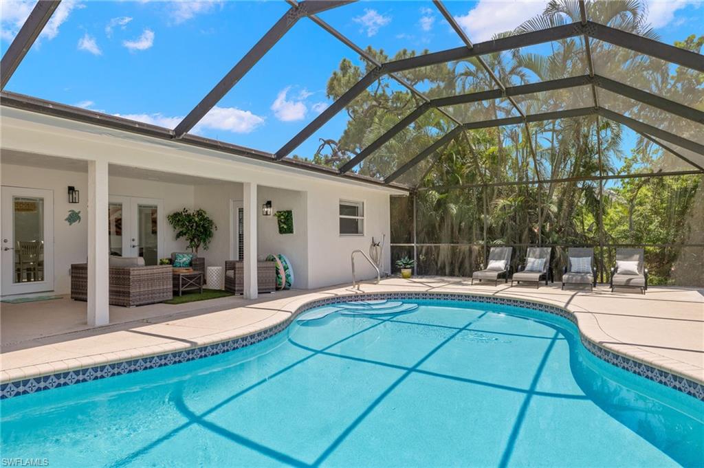 View of swimming pool featuring a lanai and a patio