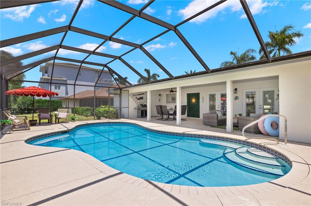 View of swimming pool featuring a patio area, french doors, glass enclosure, and grilling area