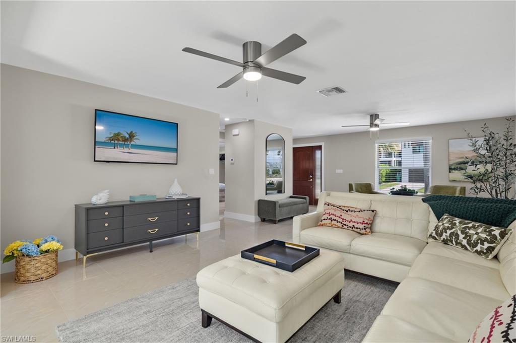 Living room featuring ceiling fan and light tile floors