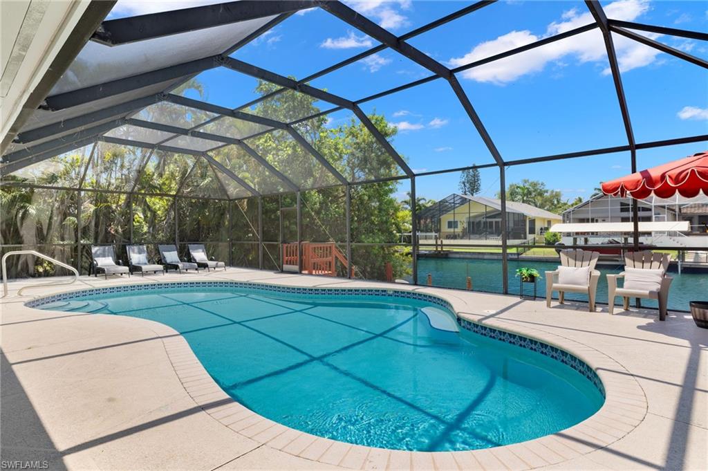 View of swimming pool featuring a lanai and a patio area