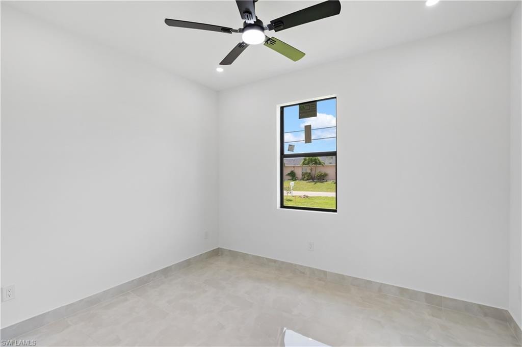Recessed lighting, ceiling fan with integrated light, single window with black trim, light-toned tile flooring, and neutral wall tones